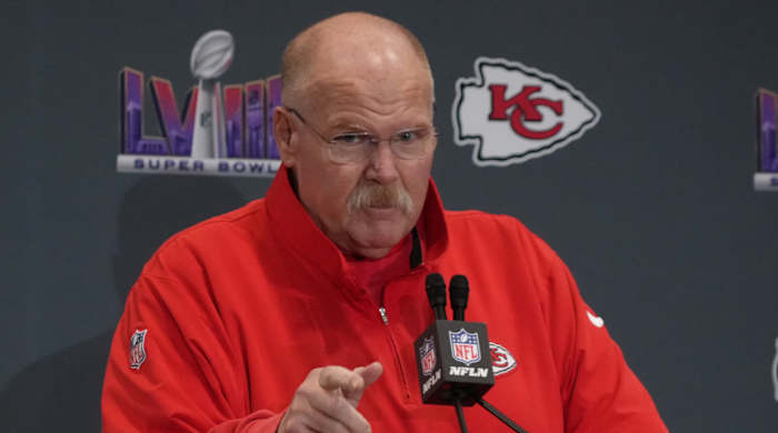 Chiefs coach Andy Reid talks on a podium at a Super Bowl LVIII press conference
